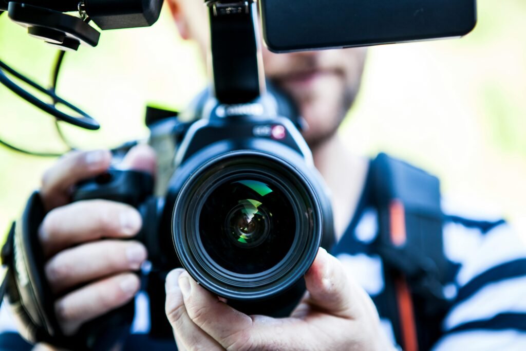 pexels-photo-320617-320617 A close-up shot of a cameraman filming, focusing on the camera lens and equipment.